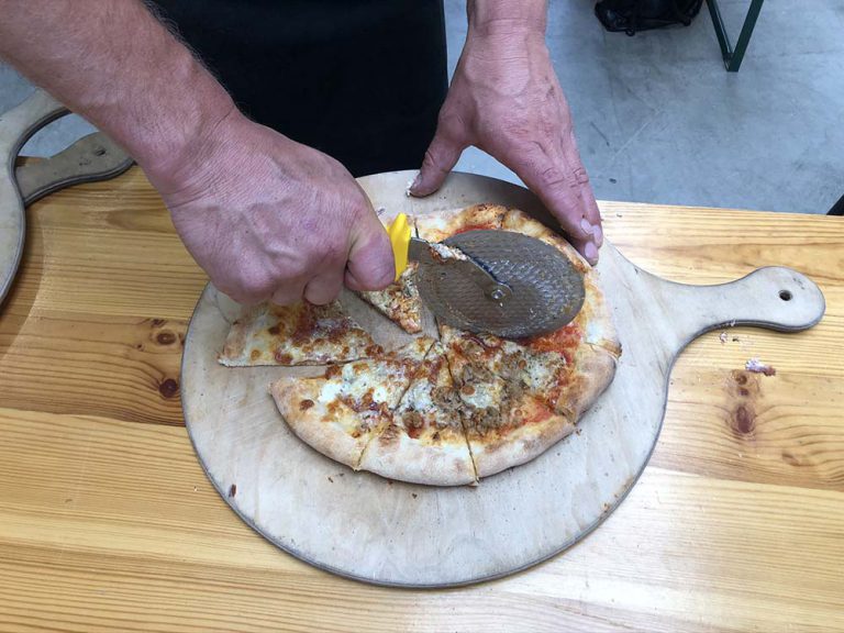 Snijden van pizza bij de pizzacursus