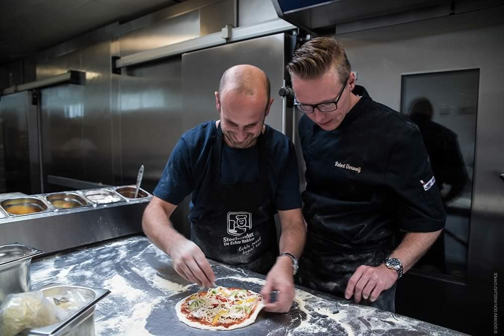 Pizza bakkers maken een pizza